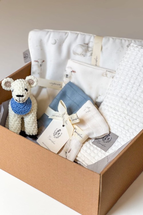 Zestaw prezentowy dla noworodka na baby shower, narodziny bądź chrzest dziecka. W zestawie: podusia do gondoli, otulacz, pieluszki ulewajk, maskotka robiona ręcznie na szydełku. Kolorystyka: ecru, brudny błękit, motywy owieczek.